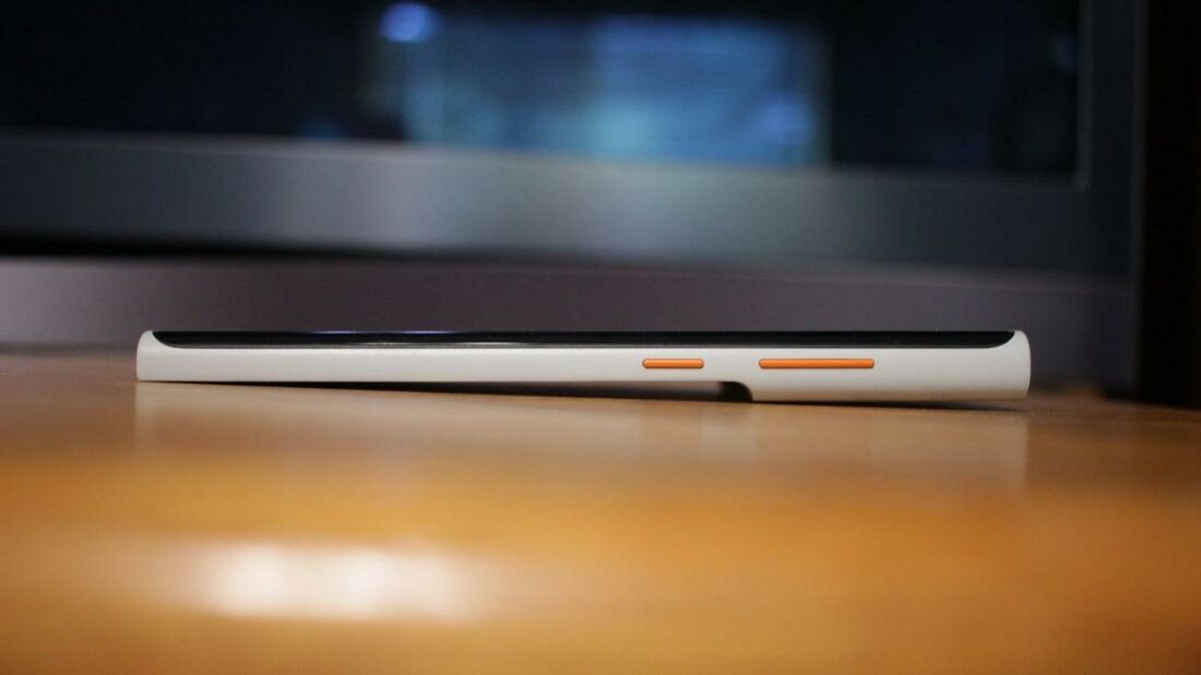 Three orange buttons (two for volume and one for power), sit upon the right side of the phone.